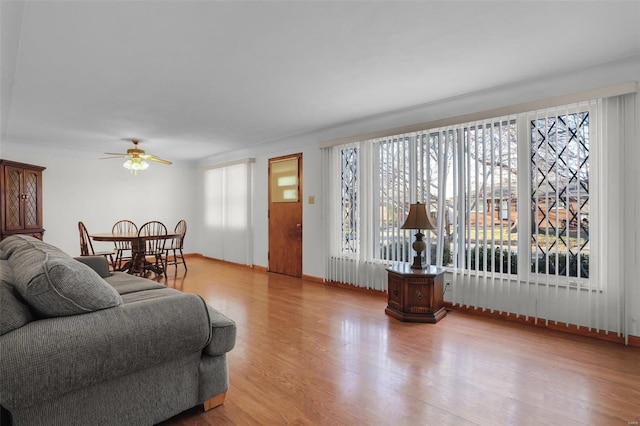 living room with light hardwood / wood-style flooring and ceiling fan