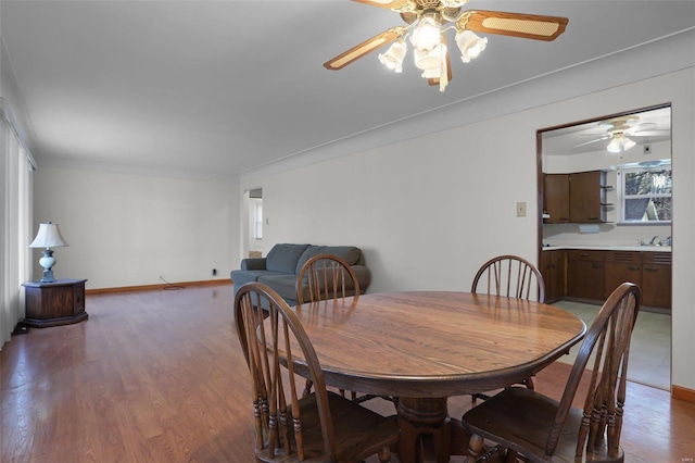 dining area featuring hardwood / wood-style flooring, ceiling fan, and sink