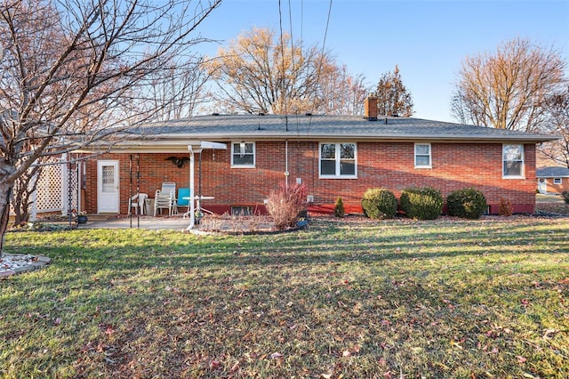 rear view of house with a lawn and a patio area