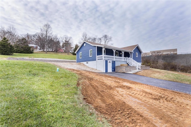 view of front of home featuring covered porch and a front lawn