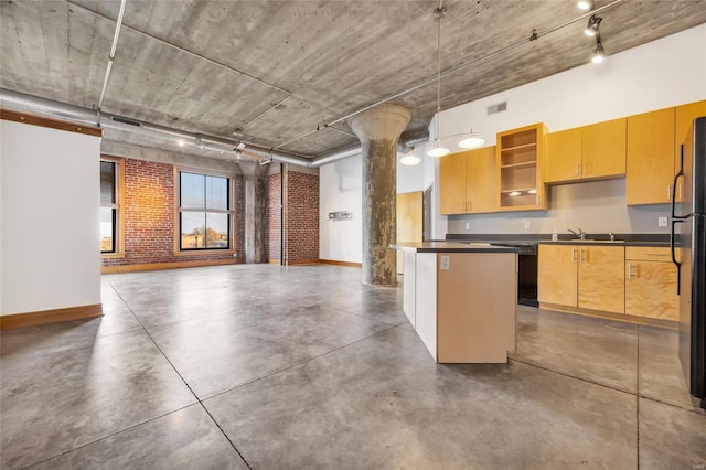 kitchen featuring sink, decorative columns, track lighting, decorative light fixtures, and a kitchen island