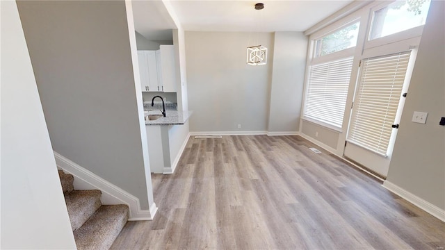 unfurnished dining area featuring light hardwood / wood-style floors and sink