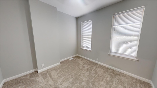 carpeted spare room featuring plenty of natural light