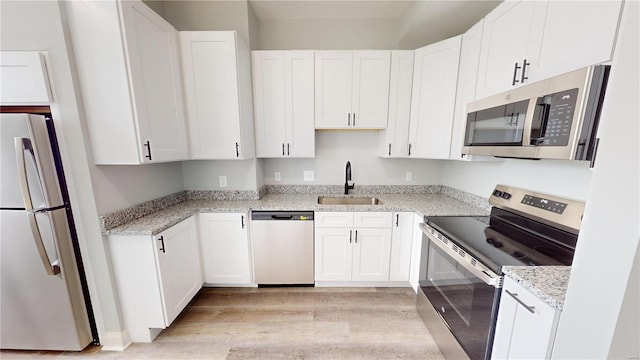 kitchen with light hardwood / wood-style floors, sink, white cabinetry, and stainless steel appliances