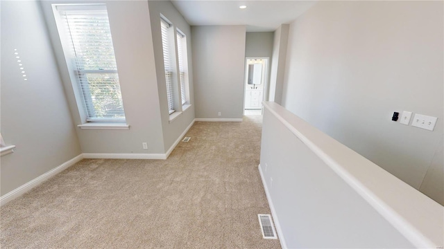 corridor with light colored carpet and plenty of natural light