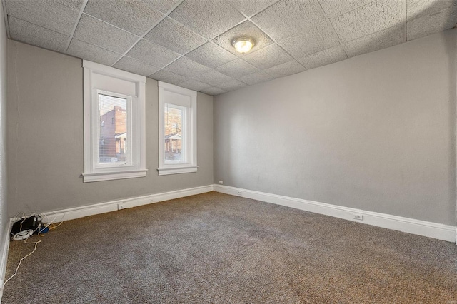 carpeted spare room with a paneled ceiling