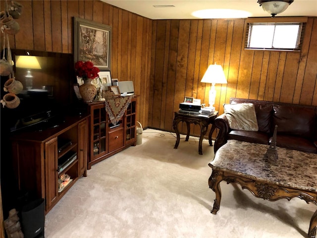 living area with wooden walls and light carpet