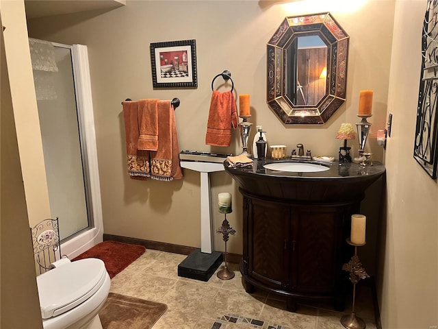 bathroom with vanity, toilet, and a shower with shower door