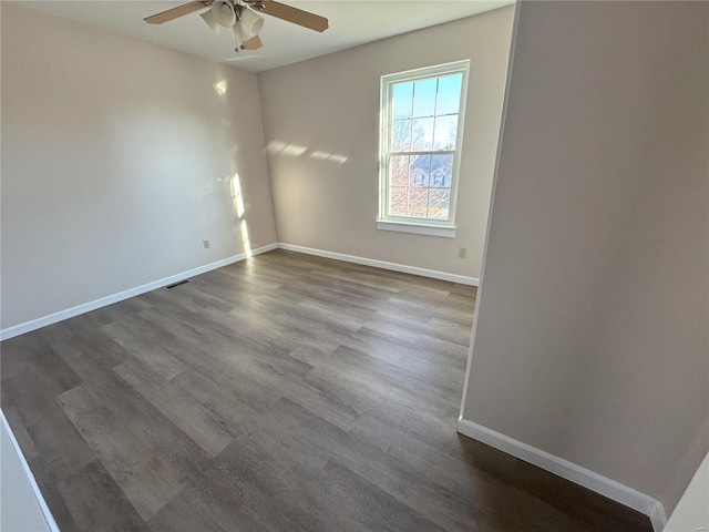 empty room featuring ceiling fan and dark wood-type flooring