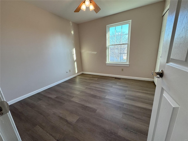 spare room with ceiling fan and dark hardwood / wood-style flooring