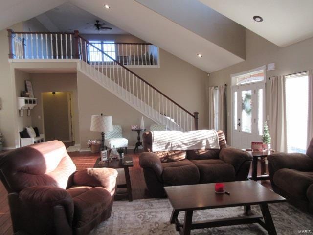 living room with ceiling fan, hardwood / wood-style floors, high vaulted ceiling, and a healthy amount of sunlight