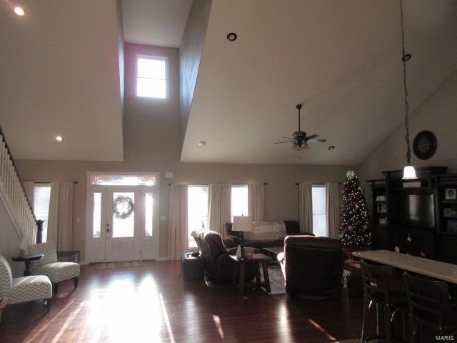 living room featuring ceiling fan, high vaulted ceiling, and hardwood / wood-style flooring