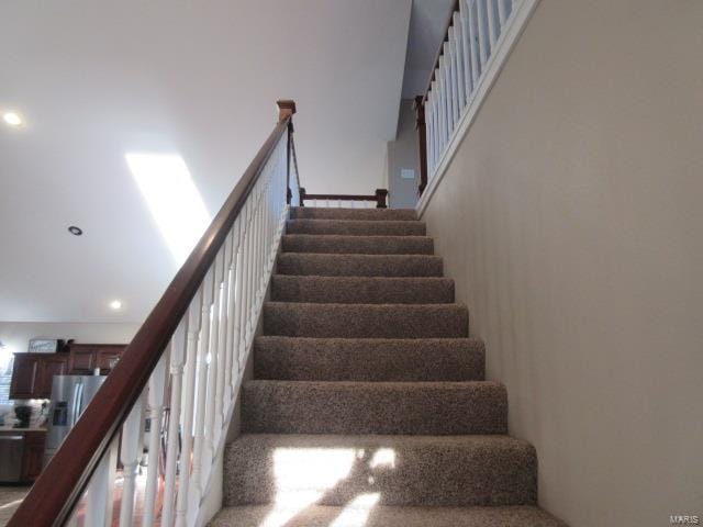 stairs featuring carpet flooring