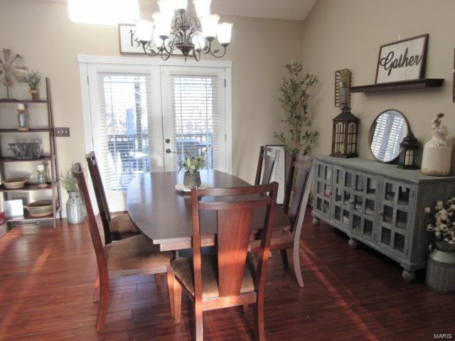 dining space featuring a chandelier, french doors, and dark wood-type flooring