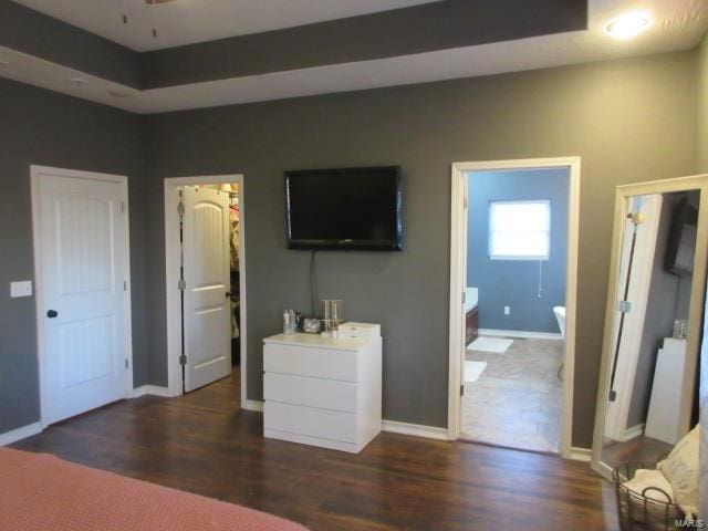 bedroom with connected bathroom and dark hardwood / wood-style floors