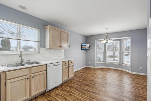 kitchen with dishwasher, hanging light fixtures, sink, light brown cabinetry, and a notable chandelier