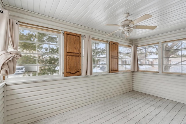 unfurnished sunroom with ceiling fan