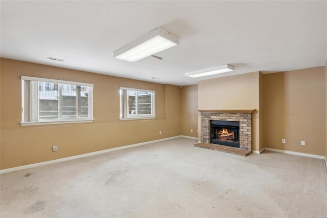 unfurnished living room featuring light colored carpet and a brick fireplace