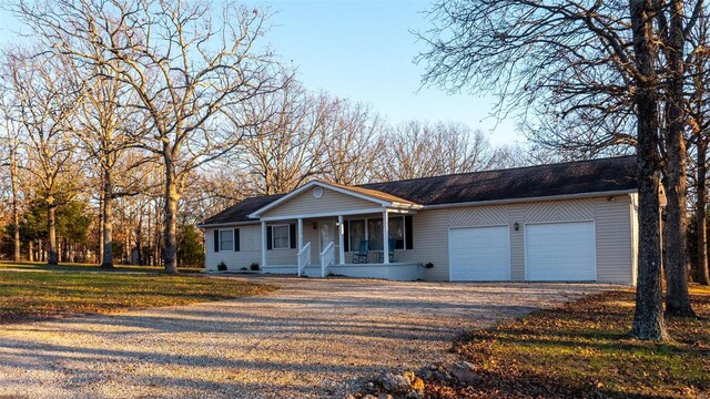 single story home with covered porch and a garage