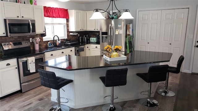 kitchen with a breakfast bar, a kitchen island, stainless steel appliances, and sink