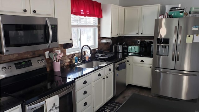 kitchen with sink, dark wood-type flooring, stainless steel appliances, backsplash, and white cabinets