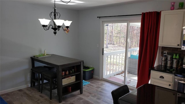 dining area with light wood-type flooring and an inviting chandelier