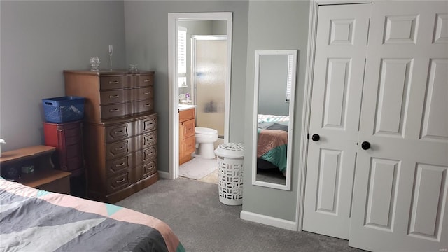 carpeted bedroom featuring ensuite bath and a closet