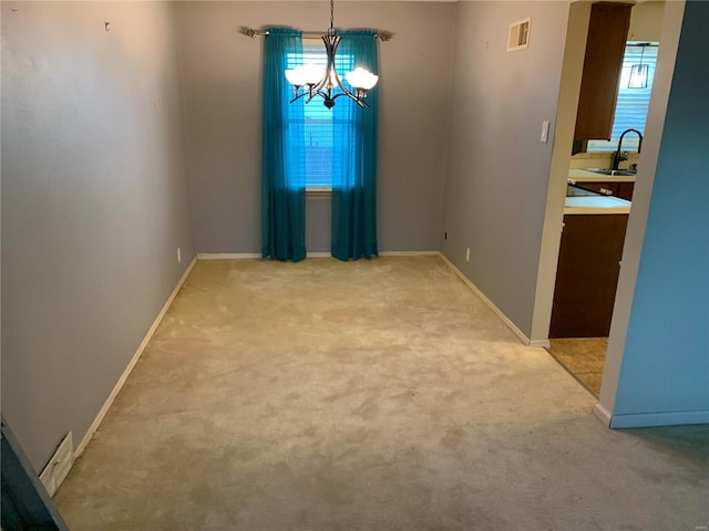 unfurnished dining area with light carpet, sink, and a chandelier