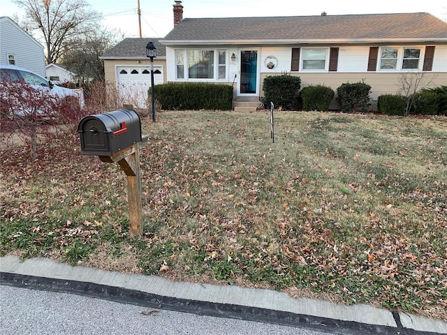 single story home with a front yard and a garage