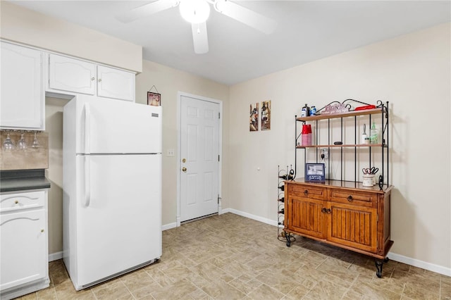 kitchen featuring white cabinets, ceiling fan, white fridge, and decorative backsplash