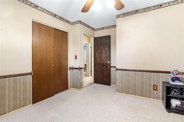 carpeted bedroom with ceiling fan and a closet