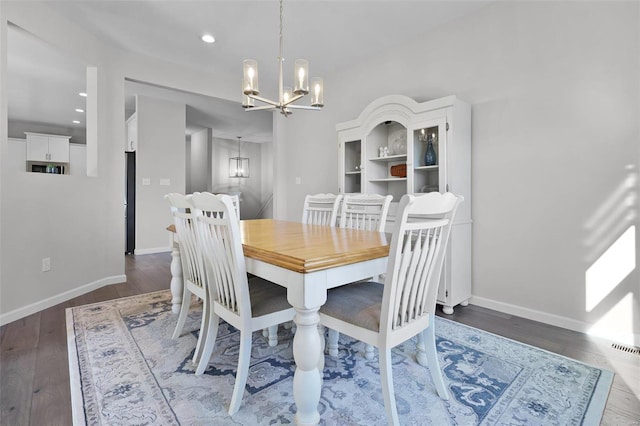 dining space with a chandelier and dark wood-type flooring