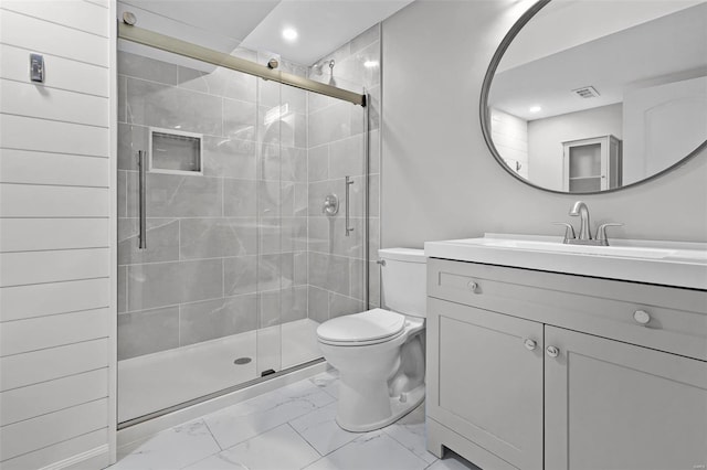 bathroom featuring a shower with door, vanity, and toilet