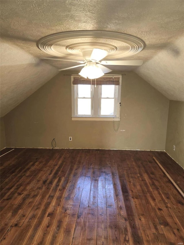 bonus room featuring dark hardwood / wood-style floors, a textured ceiling, and vaulted ceiling