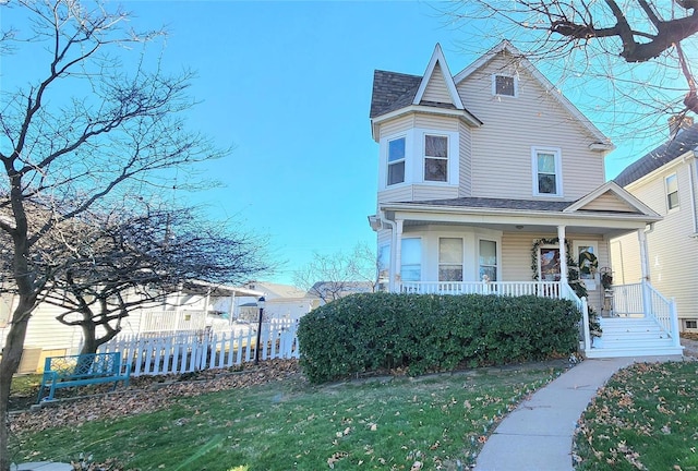 view of front of home with covered porch and a front lawn