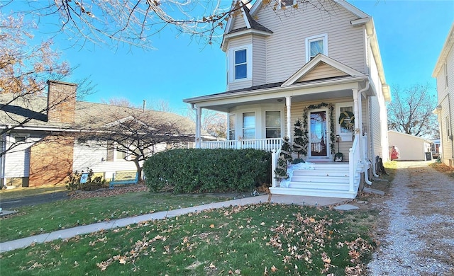 view of front facade featuring covered porch and a front yard