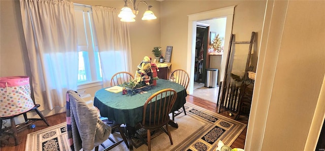 dining area with hardwood / wood-style floors and a notable chandelier