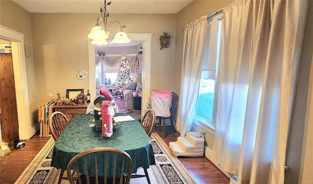 dining room with hardwood / wood-style floors and a notable chandelier