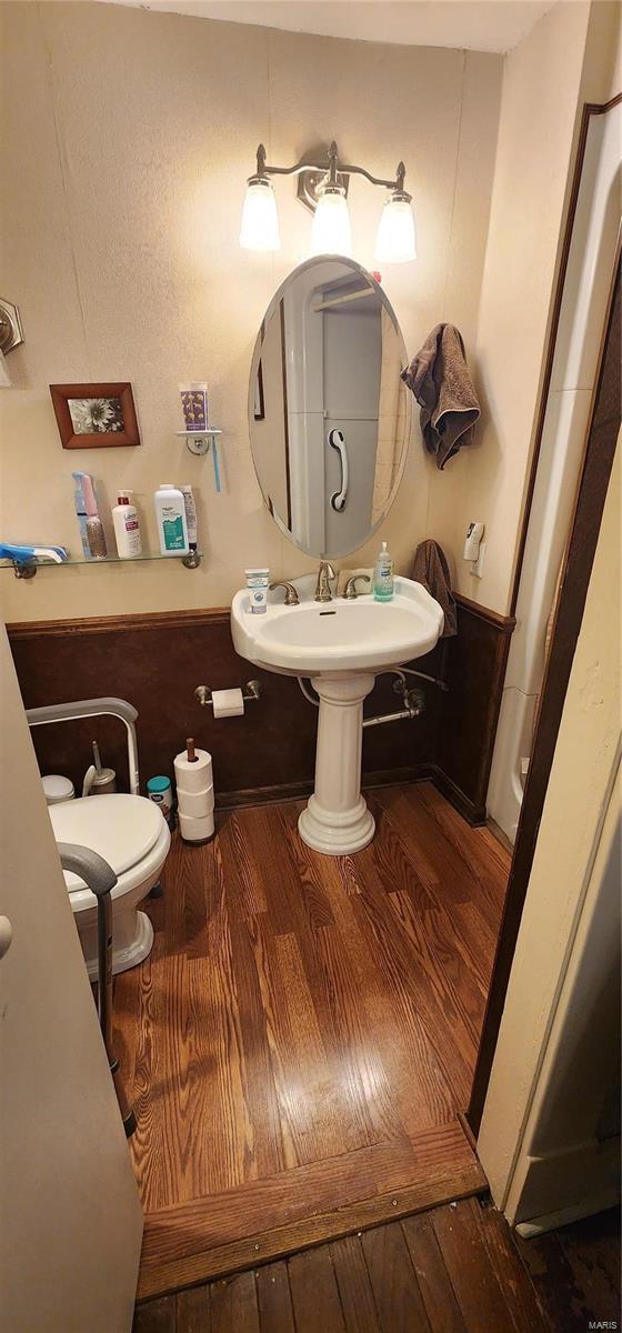 bathroom featuring hardwood / wood-style flooring and toilet