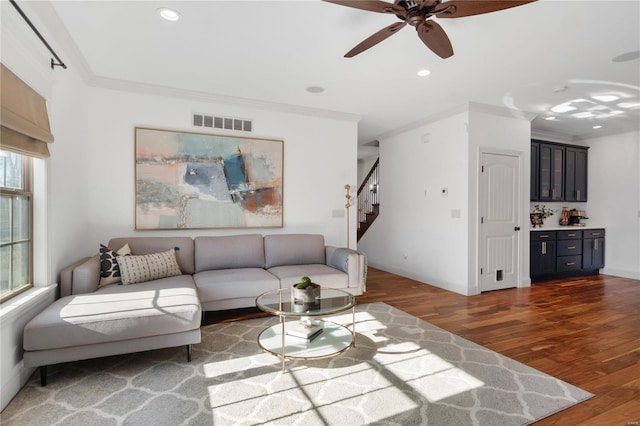 living room with dark hardwood / wood-style floors, a healthy amount of sunlight, crown molding, and ceiling fan