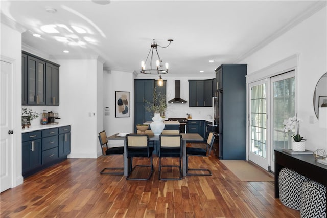 dining space featuring a chandelier, dark wood-type flooring, and ornamental molding