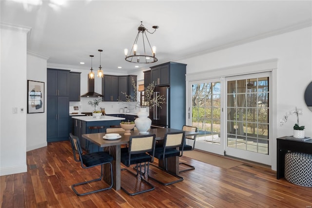 dining area featuring dark hardwood / wood-style floors, ornamental molding, and an inviting chandelier