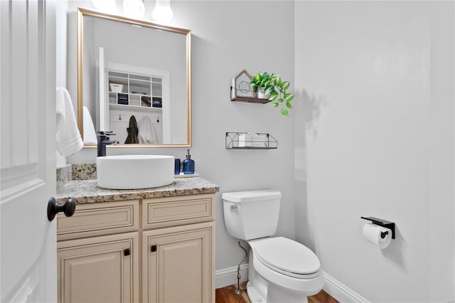 bathroom featuring hardwood / wood-style floors, vanity, and toilet