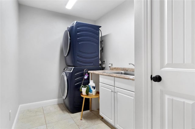 laundry room featuring cabinets, light tile patterned floors, stacked washing maching and dryer, and sink