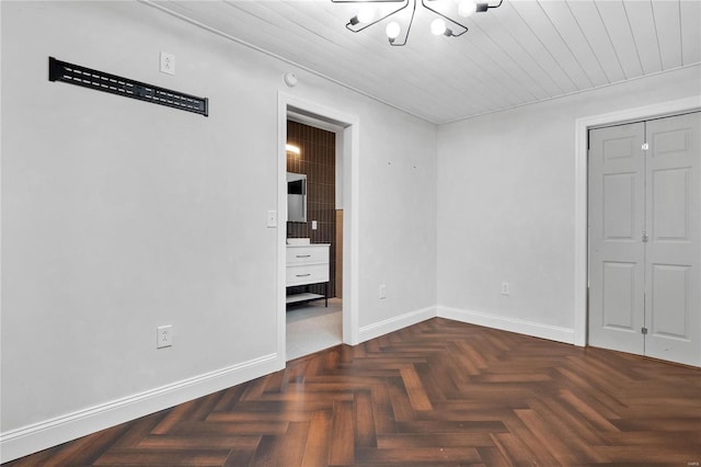 unfurnished bedroom featuring dark parquet flooring