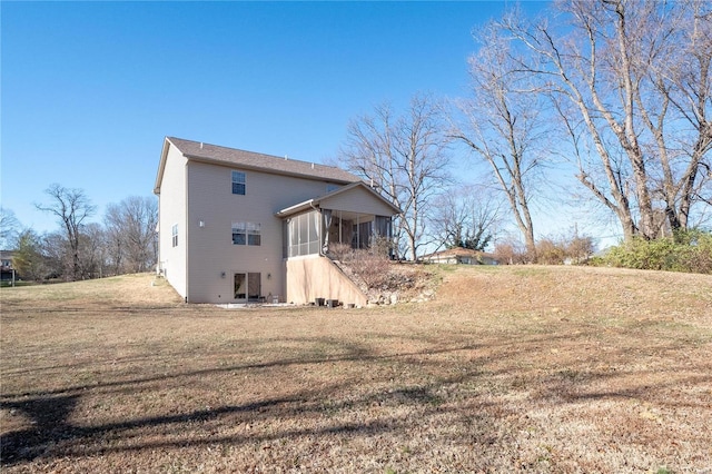 rear view of house with a yard and a sunroom