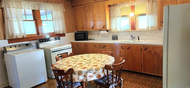 kitchen featuring tasteful backsplash, washer / clothes dryer, sink, and white appliances