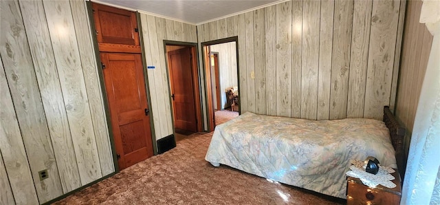 bedroom with wooden walls and carpet floors