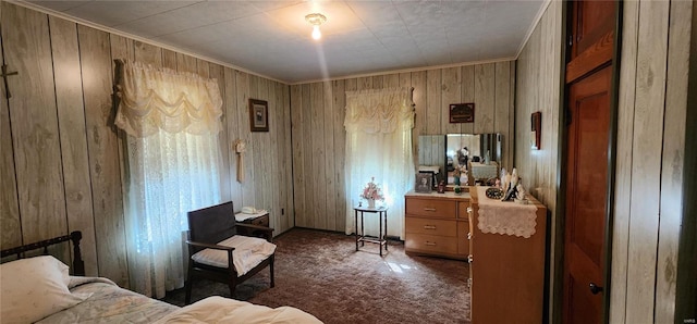 carpeted bedroom featuring ornamental molding and wooden walls