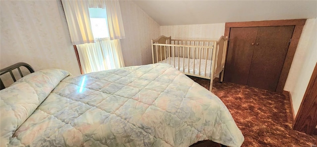 bedroom with a closet, carpet, and vaulted ceiling